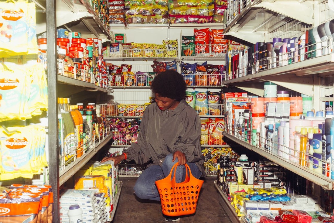 A grocery shopper pausing in an aisle or examining a price label