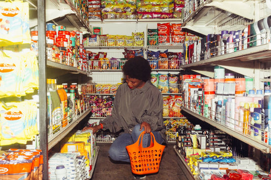A grocery shopper pausing in an aisle or examining a price label